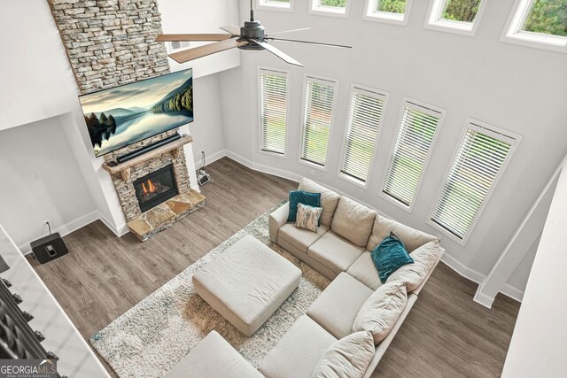 1606 Chancery Ln, Lithia Springs, GA 30122 - living area with healthy amount of natural light, a fireplace, a towering ceiling, a ceiling fan, and baseboards