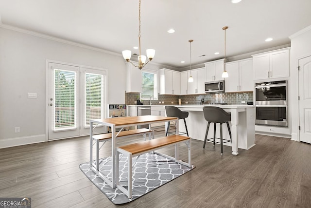 1606 Chancery Ln, Lithia Springs, GA 30122 - dining room featuring ornamental molding, recessed lighting, dark wood finished floors, a chandelier, and baseboards