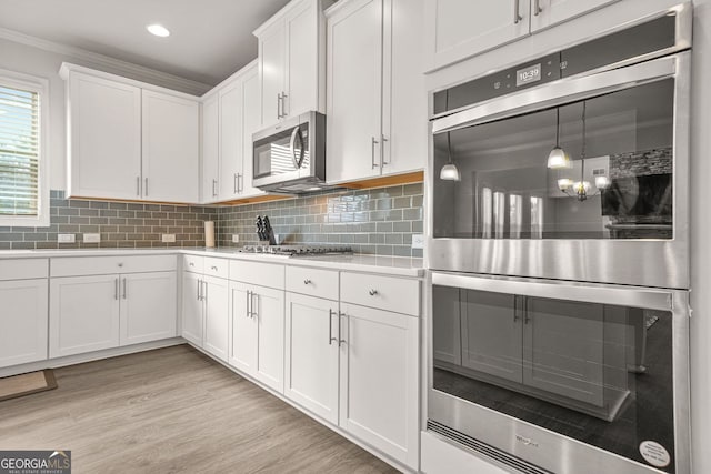 1606 Chancery Ln, Lithia Springs, GA 30122 - kitchen featuring appliances with stainless steel finishes, light countertops, white cabinets, tasteful backsplash, and recessed lighting