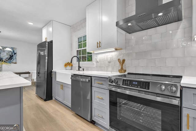 3182 Wakefield Dr, Decatur, GA 30034 - kitchen featuring gray cabinetry, range hood, appliances with stainless steel finishes, and decorative backsplash