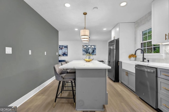3182 Wakefield Dr, Decatur, GA 30034 - kitchen with gray cabinets, recessed lighting, appliances with stainless steel finishes, a kitchen island, and light wood finished floors