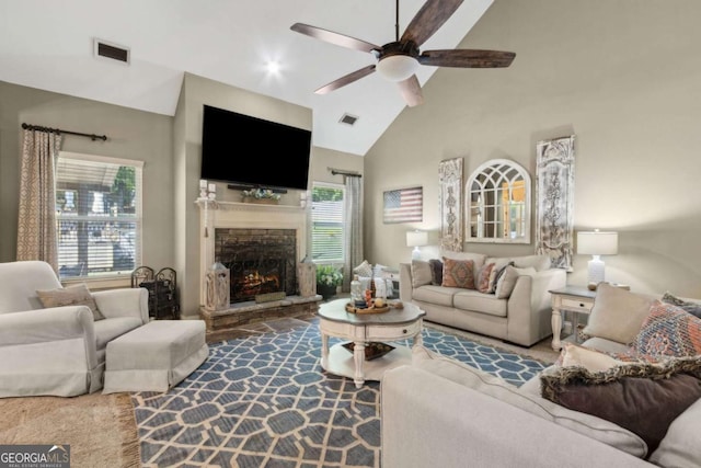 living room with a ceiling fan, high vaulted ceiling, visible vents, and a fireplace