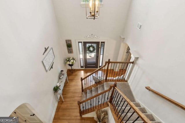 entryway featuring a towering ceiling and wood finished floors