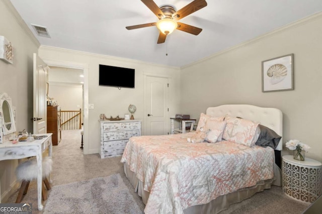 bedroom featuring visible vents, ornamental molding, ceiling fan, and light colored carpet