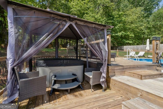 deck with a fenced in pool, a gazebo, a fenced backyard, and a hot tub