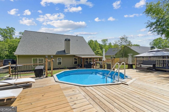 view of pool with a gazebo, a wooden deck, a fenced backyard, and a fenced in pool