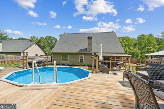 view of pool with a wooden deck, a fenced backyard, and a fenced in pool