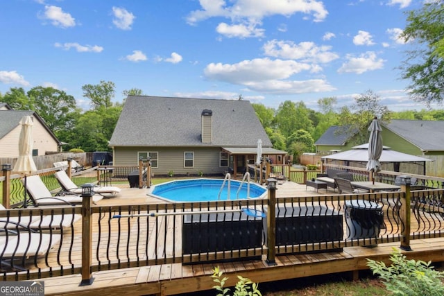 view of swimming pool with a fenced in pool, outdoor dining space, a deck, and a fenced backyard