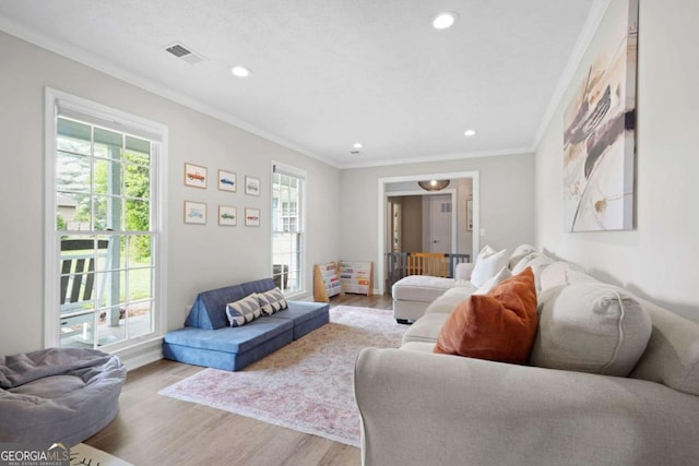 living room with crown molding, recessed lighting, visible vents, and wood finished floors