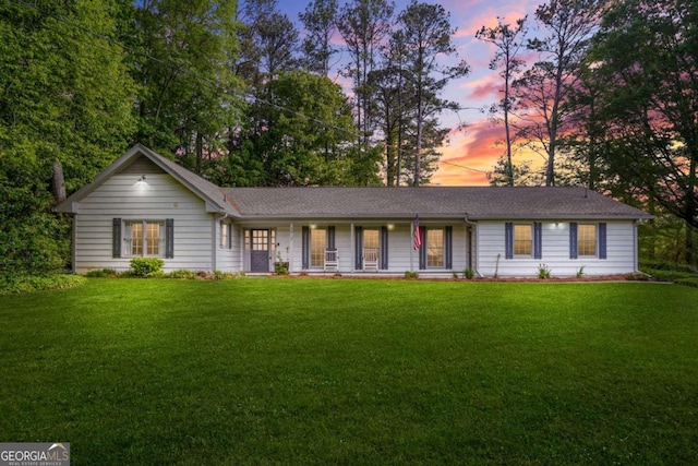 ranch-style home with a yard and covered porch