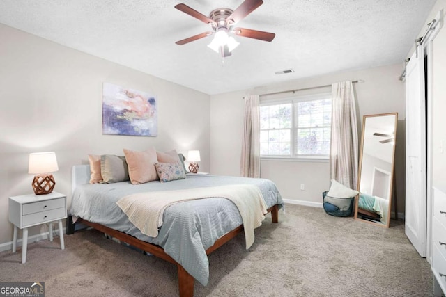 carpeted bedroom with baseboards, a ceiling fan, a textured ceiling, and visible vents