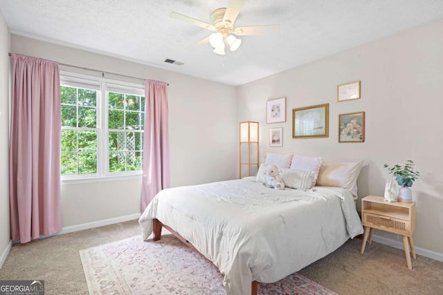 bedroom featuring baseboards, carpet flooring, a ceiling fan, and visible vents