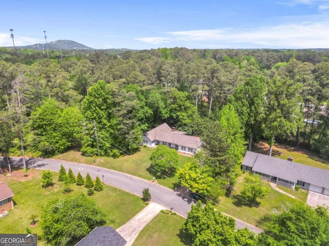 birds eye view of property featuring a mountain view and a wooded view