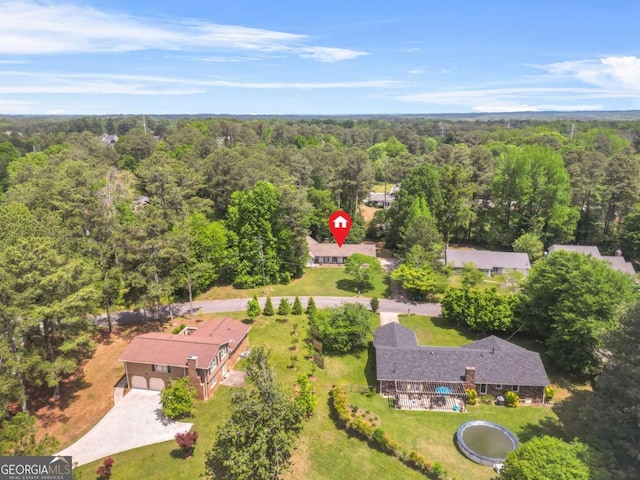 birds eye view of property featuring a forest view