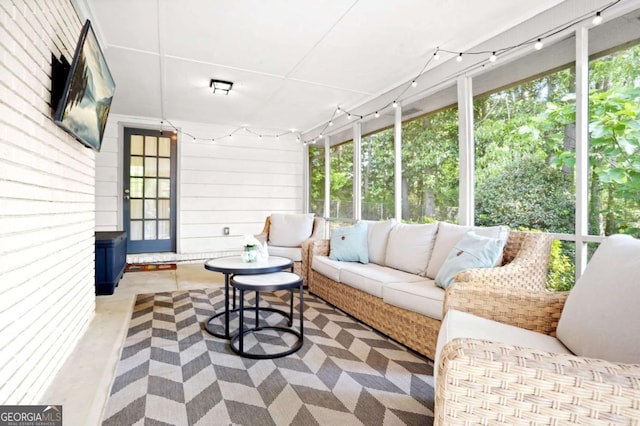sunroom featuring track lighting, outdoor lounge area, and a wealth of natural light
