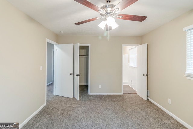 unfurnished bedroom featuring carpet floors, baseboards, a closet, and a walk in closet