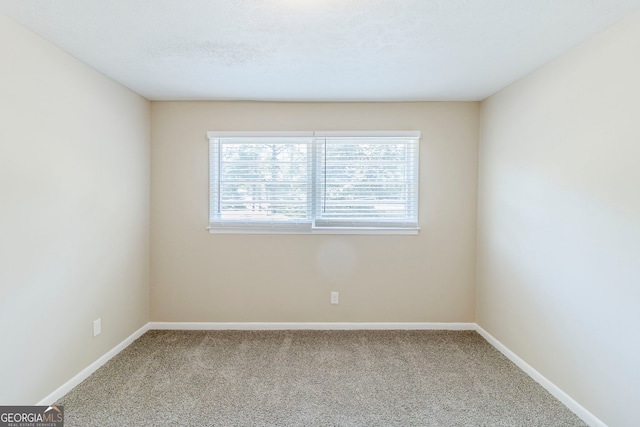 spare room featuring baseboards and carpet