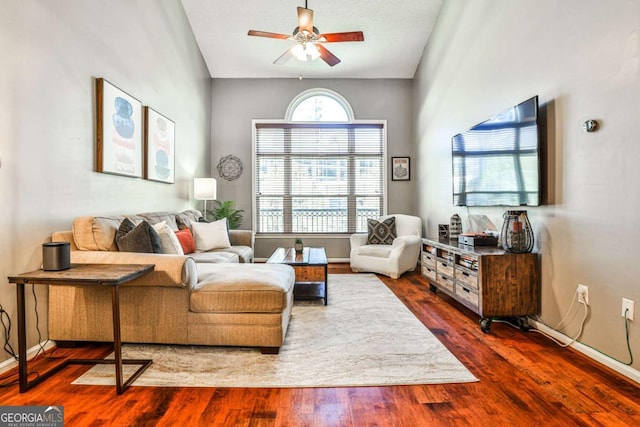 living room with baseboards, wood finished floors, and a ceiling fan