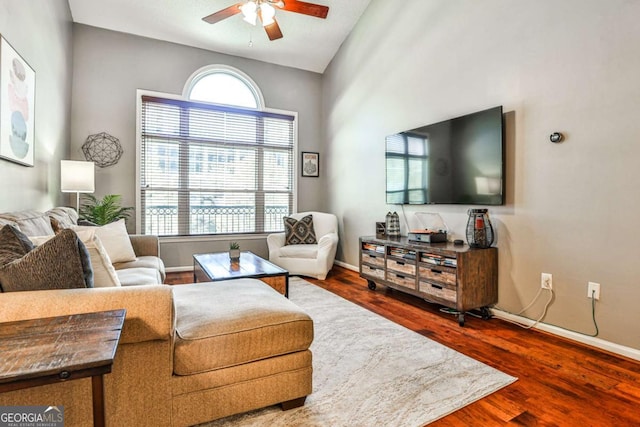 living area featuring ceiling fan, baseboards, and wood finished floors
