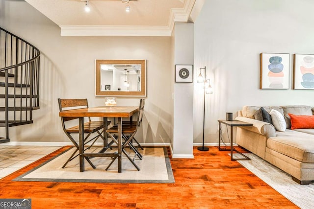 dining room with crown molding, stairs, baseboards, and wood finished floors