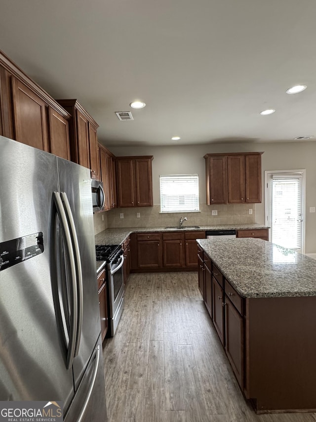 3592 Hancock Vw, Decatur, GA 30034 - kitchen with tasteful backsplash, light stone counters, appliances with stainless steel finishes, light wood-type flooring, and visible vents