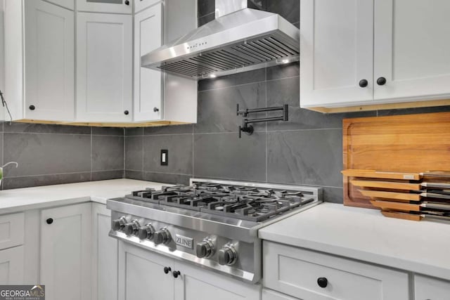 kitchen with white cabinetry, decorative backsplash, stainless steel gas cooktop, and wall chimney exhaust hood
