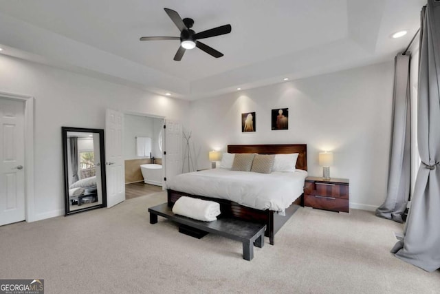bedroom featuring recessed lighting, ensuite bath, carpet floors, baseboards, and a tray ceiling