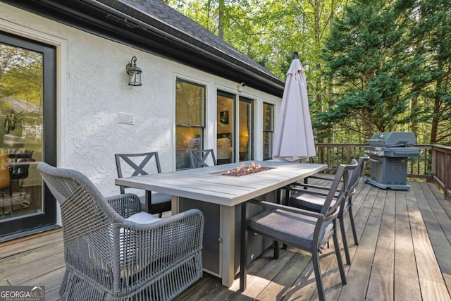 deck with a grill, an outdoor fire pit, and outdoor dining area