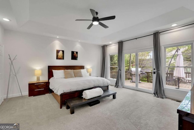 bedroom featuring visible vents, a tray ceiling, recessed lighting, light carpet, and access to outside