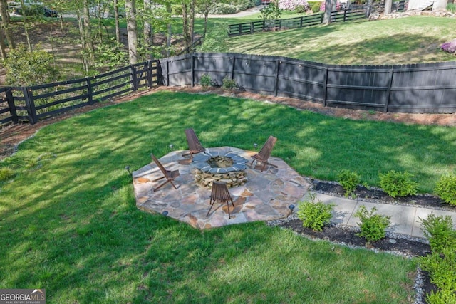 view of yard featuring a fire pit, a fenced backyard, and a patio area