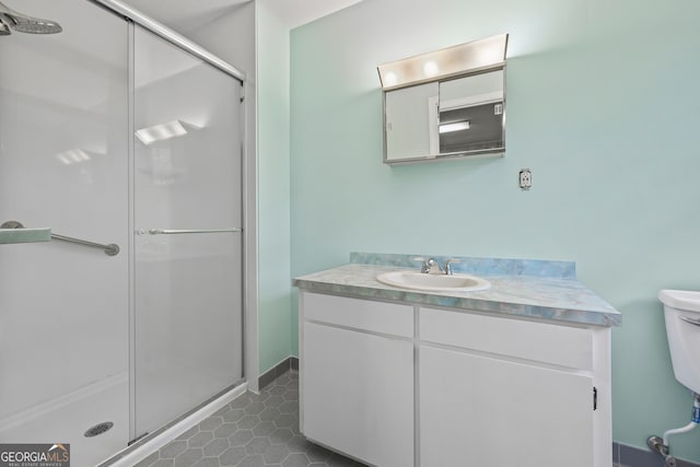 full bath with vanity, toilet, tile patterned floors, and a stall shower