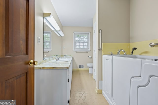 bathroom with tile patterned flooring, vanity, toilet, baseboards, and visible vents