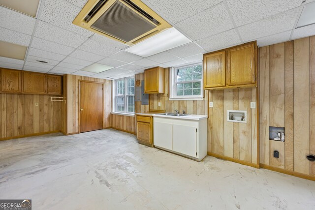 interior space featuring baseboards, wood walls, and unfinished concrete flooring