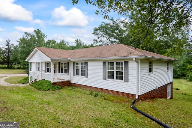 view of front of property featuring a front lawn, roof with shingles, and covered porch