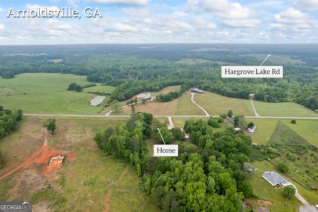 birds eye view of property featuring a view of trees and a rural view