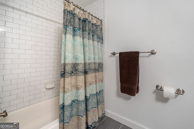 full bathroom with baseboards and shower / bath combo