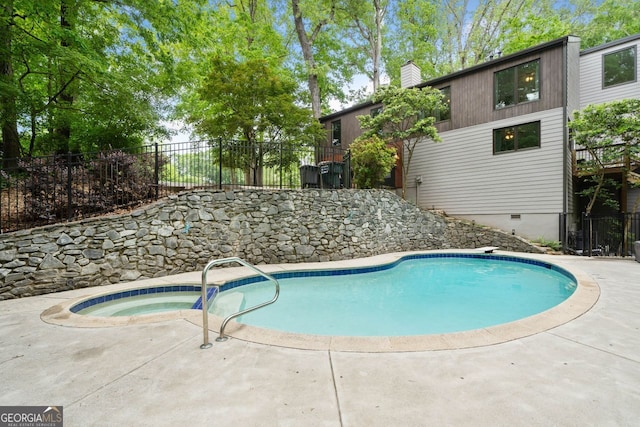 view of pool featuring fence, a fenced in pool, and an in ground hot tub