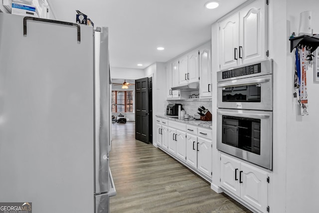 4220 Chapel Hill Farms Dr, Douglasville, GA 30135 - kitchen with appliances with stainless steel finishes, white cabinetry, backsplash, light wood-type flooring, and recessed lighting