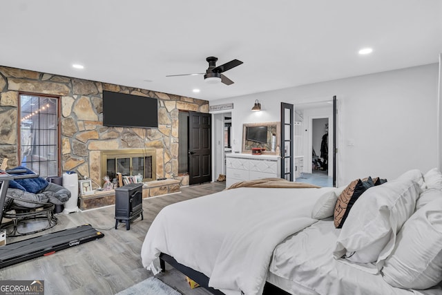 4220 Chapel Hill Farms Dr, Douglasville, GA 30135 - bedroom featuring light wood-style floors, a fireplace, ceiling fan, and recessed lighting