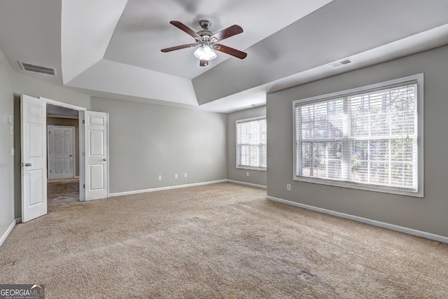unfurnished bedroom with carpet, a raised ceiling, visible vents, and baseboards