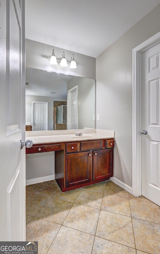 bathroom featuring baseboards, tile patterned floors, and vanity