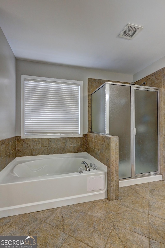 full bathroom featuring a garden tub, a stall shower, and visible vents