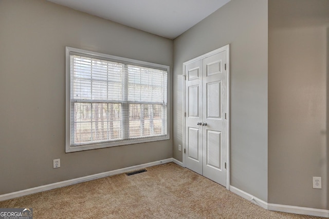unfurnished bedroom featuring visible vents, baseboards, and carpet floors