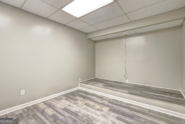 finished basement with baseboards, wood finished floors, and a drop ceiling