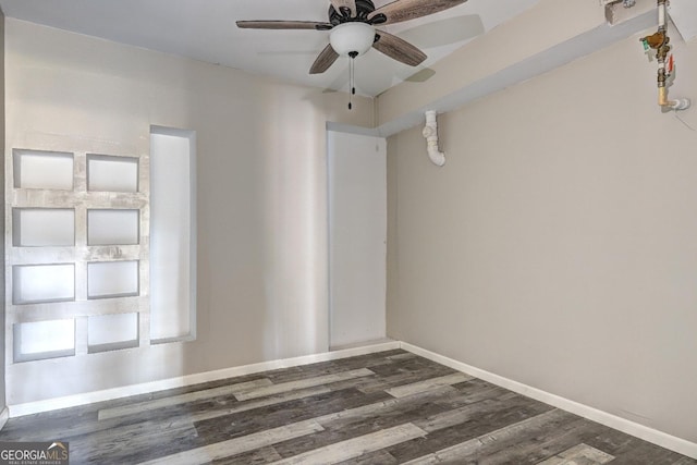 empty room with wood finished floors, a ceiling fan, and baseboards