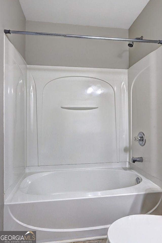 bathroom featuring toilet and  shower combination