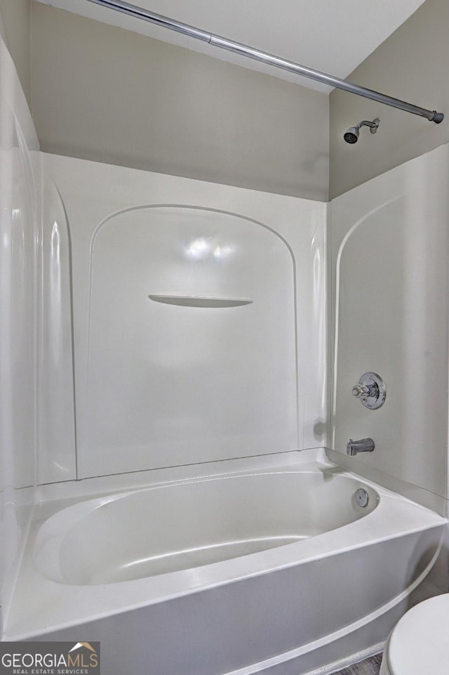 bathroom with toilet and bathtub / shower combination