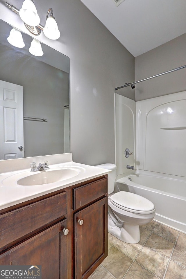 bathroom featuring toilet, vanity, and  shower combination
