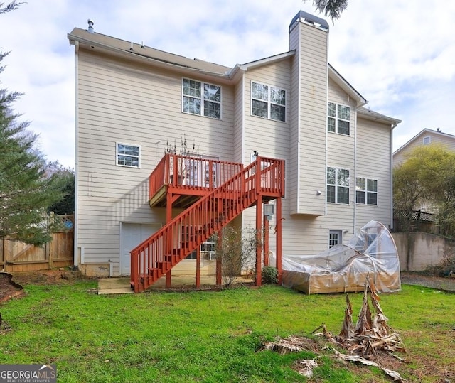 back of property featuring a wooden deck, stairway, a yard, a chimney, and fence