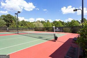 view of tennis court featuring fence and community basketball court